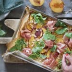 Flammenkuchen con pesche, prosciutto crudo e rucola